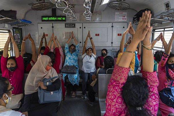 9. "Banliyö trenindeki yolcular, Hindistan'ın Mumbai kentinde Dünya Kadınlar Günü için düzenlenen bir yoga seansına katılıyor."