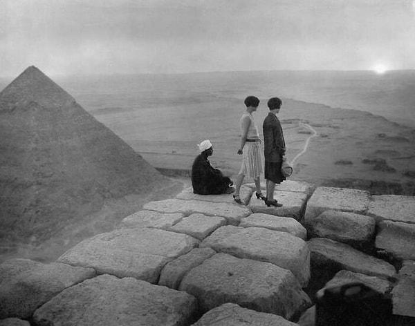 11. İki Avrupalı turist kadın ve piramitlerin tepesinde gün batımını izleyen yerli adam - 1925: