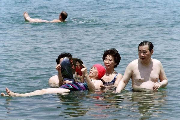 6. Çin Başbakanı Li Peng'in eşi Zhu Lin, kocasının yanında yüzerken bir dergi okuyor - Ürdün 1991: