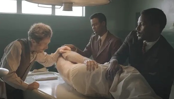 3. Amsterdam dizisinde Ed Begley Jr. bir cesedi oynamasına rağmen kendini örtmek için üzerindeki çarşafı tutuyor.