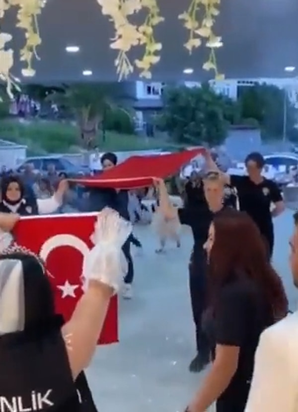 Türk Bayrağı ile düğün alanına giren gelinin arkadaşları, gelinin gelinliğinin üzerine özel güvenlik yeleği giydirip bir de Türk Bayrağı hediye ettiler.