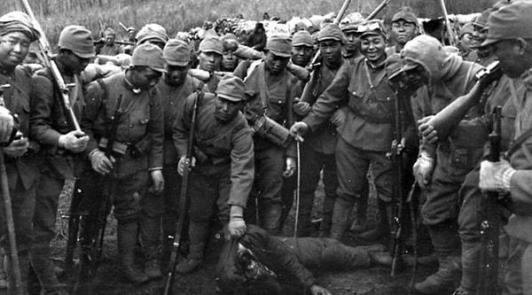 7. Japon askerleri Yangtze Vadisi'nde başı kesilmiş bir Çin askerinin cesedinin etrafında poz veriyor. (1937)