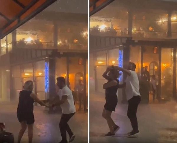 Şiddetli rüzgar ve yağmura aldırış etmeyen çift, yağmurun altında dans ederek izleyenlerin gözünü gönlünü güzelleştirdi.