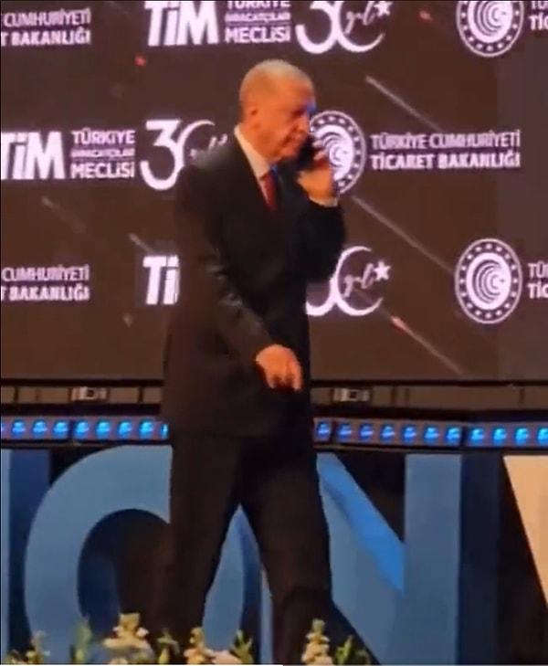 Gelen telefonu cevaplayan Erdoğan, konuşmasına ara vererek sahneden indi.