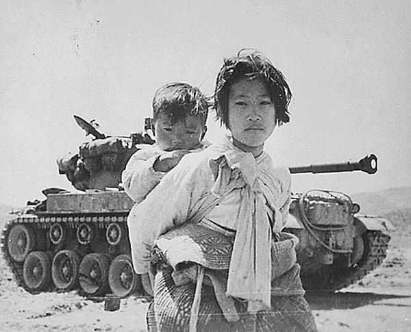 5. Kardeşi sırtında bir şekilde gezen ve savaştan bıkmış Koreli bir kız.