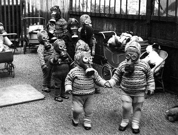 14. Savaş sırasında gaz maskesi takmış bir şekilde oynayan İngiltereli çocuklar.