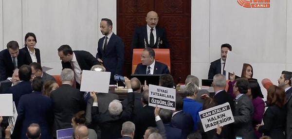 TBMM Başkanvekili Bozdağ'ın kararı okuması sırasında mecliste tansiyon yükseldi. Vekiller kürsüye yürüyerek kararı protesto ederken, Bozdağ'a Anayasa kitapçığı atıldı.