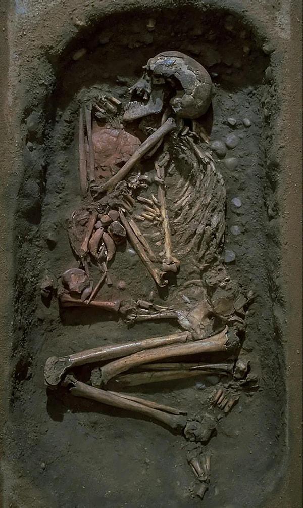 2. Yaklaşık 7000 yıl önce İsveç'teki Skateholm şehrinde gömülmüş 60'lı yaşlarında bir adam. Yanında daha sonra gömülen ve üzerine kırmızı aşı boyası serpilen 4-5 yaşlarında bir çocuk yatıyor. Çocuğun göğsünde ayı dişlerinden ve kehribar parçalarından yapılmış takılar bulunmakta.
