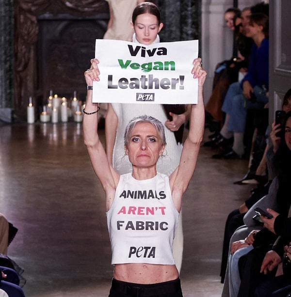 Üzerlerine “Hayvanlar kumaş değildir" yazılı tişörtler giyen göstericiler “Yaşasın vegan deri" yazılı pankartlarla podyumda yürüdüler.