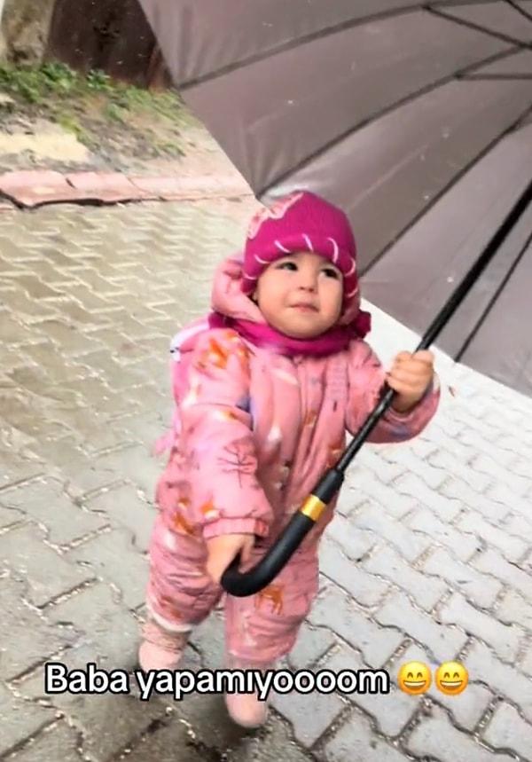 Minik bebek kendinden büyük şemsiyeyi tutmaya çalışırken çok çaba gösterse de pes etti.