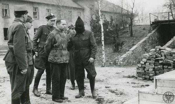 11. Auschwitz Kampı Komutanı, Rudolf Hoess, Nazi ölüm kampı Auschwitz Stammlager'deki krematoryumun yanındaki darağacına doğru götürülürken. (Polonya, 1947)