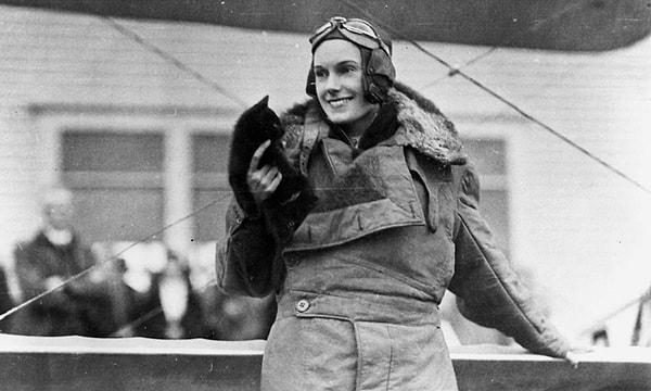 11. İngiltere ile Yeni Zelanda arasındaki ilk solo uçuşu tamamlamasıyla ünlü Yeni Zelandalı pilot Jean Batten, Wellington'daki Rongotai Havalimanı'nda bir kediyle poz veriyor. (1930'lar civarı.)