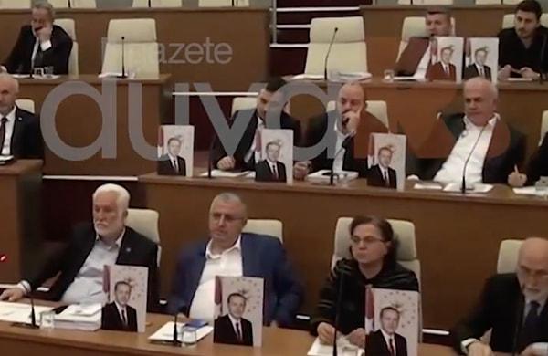Durumu protesto etmek isteyen AKP'li üyeler, meclis toplantısında sıralarına Cumhurbaşkanı Erdoğan'ın fotoğraflarını koydu.