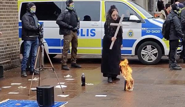 Ateşe haç tutarak eylemini gerçekleştiren kadın tepki çekti.