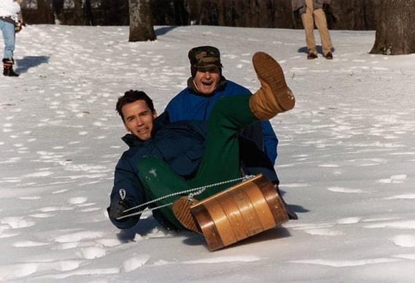 12. Eski Amerikan başkanı George H.W. Bush, Camp David tesislerinde Arnold Schwarzenegger ile kızakla kayarken. (1991)