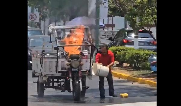 Meksika'da vatandaşlar yolun ortasında aniden alevlenen motoru öncelikle kova kova suyla söndürmeyi denedi. Değişen bir şey olmadı.