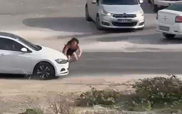 Bir süre sonra kadın dikkatlice karayoluna koşarak akan trafikte kendini bir aracın önüne atmaya çalışıyor ancak bunda da tam başarılı olamıyor.
