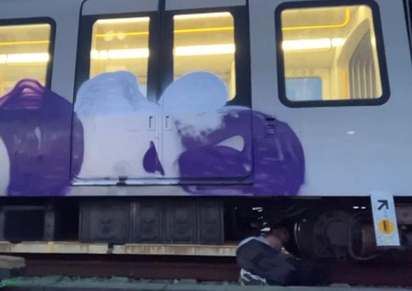 Bir kişi, grafiti yaparken yakalanmamak için trenin altına girdiği sırada tren birden hareket etmeye başladı.