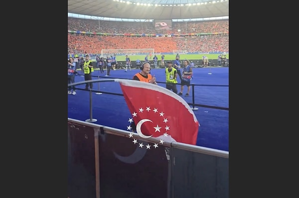 Alman bir görevli, tribünden düşen Türk bayrağını yerden kaldırdı.