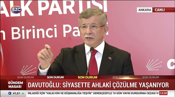 Davutoğlu ekranlarda konuşurken kendisine yansıtılan ışıklar sebebiyle anlık da olsa sarışın bir görünüm kazandı.