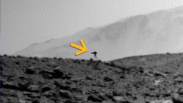 NASA'ya ait Curiosity keşif aracının kızıl gezegenden gönderdiği sıradan bir manzara fotoğrafı, sol köşesinde beliren beklenmedik bir misafir yüzünden bilim dünyasında büyük merak uyandırdı.