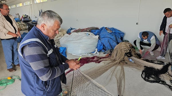 Olumsuz hava nedeniyle denize açılamayan balıkçılar ağ ve tekne bakımı yapıyor.